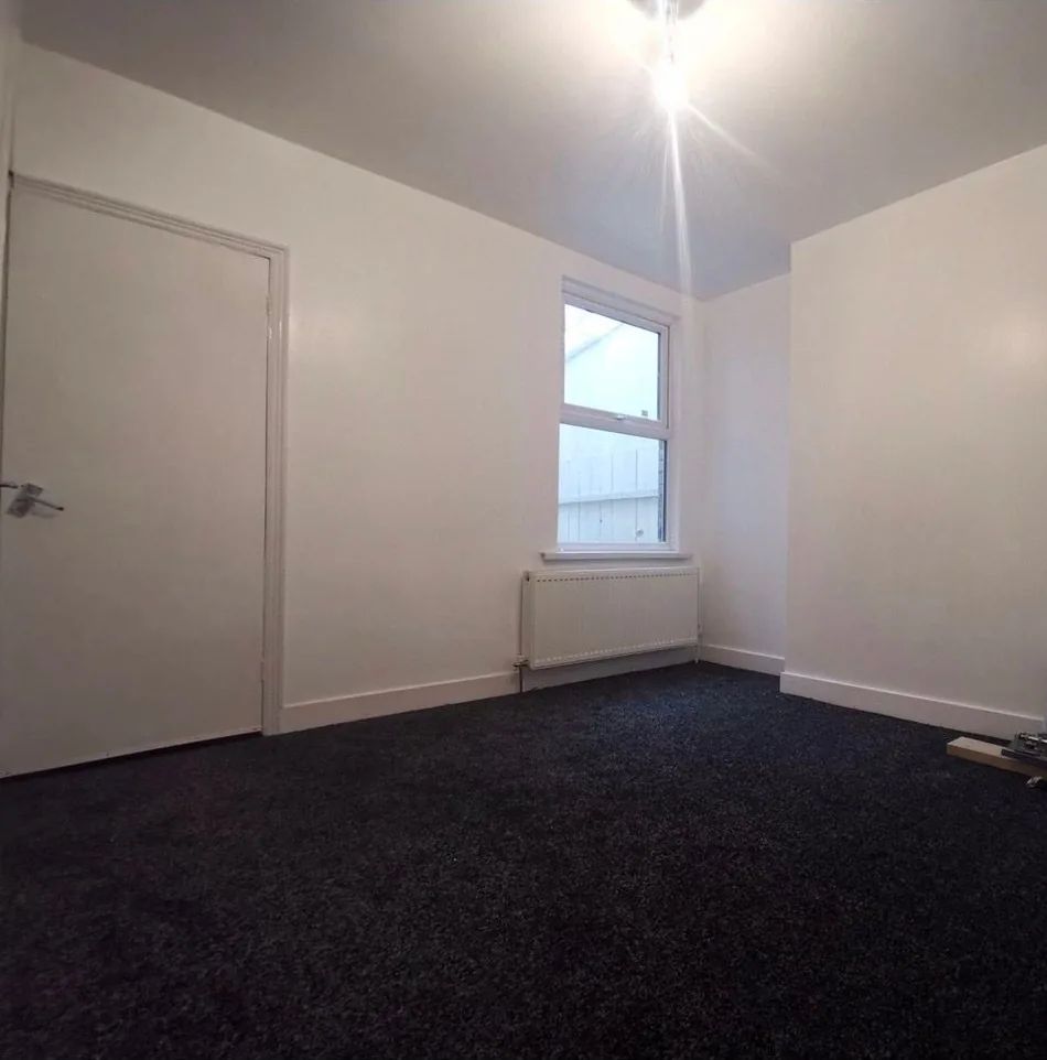 A finished room with a radiator fitted under the window, part of the new central heating system
